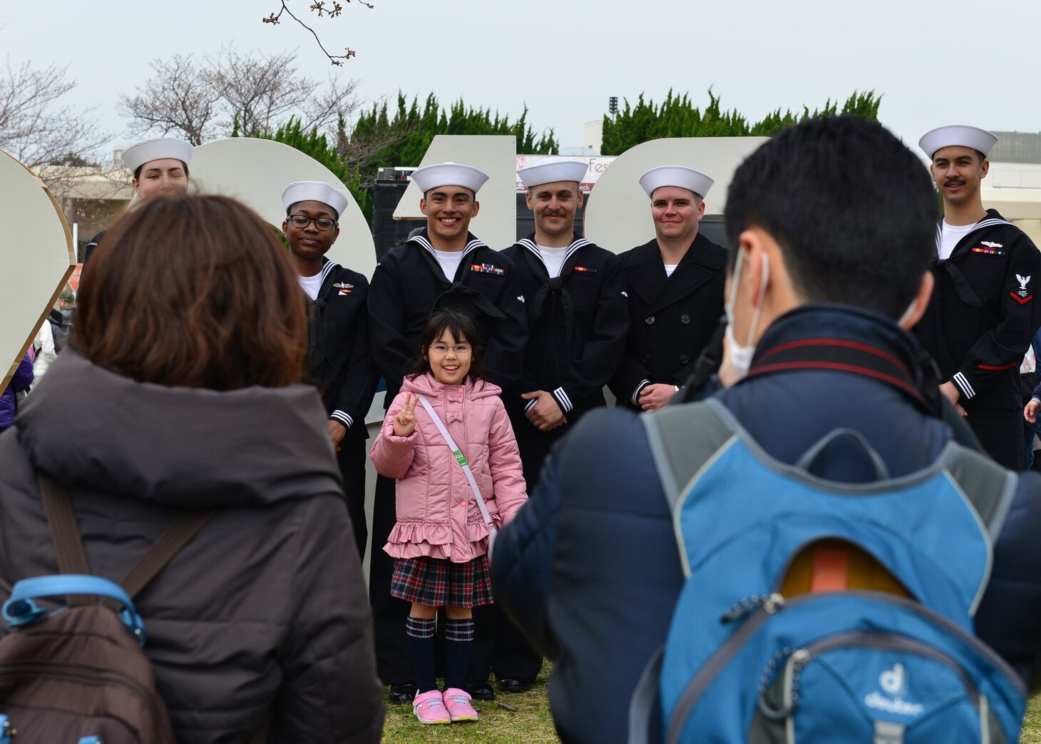 Sailors assigned to the USS Ronald Reagan (CVN 76) pose for photos with visitors during the 26th annual Spring Festival, March 30 onboard Fleet Activities (FLEACT) Yokosuka. FLEACT Yokosuka provides, maintains, and operates base facilities and services in support of the U.S. 7th Fleet's forward-deployed naval forces, 71 tenant commands, and more than 27,000 military and civilian personnel.