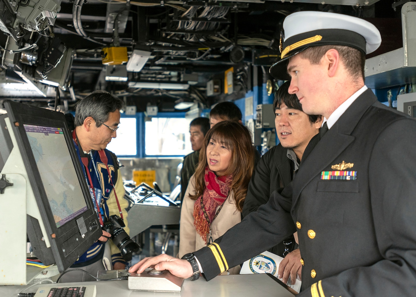 LTJG Brandon Vitton gives Japanese media a tour of the Ticonderoga-class guided-missile cruiser USS Chancellorsville’s (CG 62) bridge on March 30. Chancellorsville, which is forward deployed at U.S. Fleet Activities Yokosuka, welcomed media and thousands of other Japanese guests during the installation’s 26th annual Spring Festival. Fleet Activities Yokosuka provides, maintains, and operates base facilities and services in support of 7th Fleet's forward-deployed naval forces, 71 tenant commands, and more than 27,000 military and civilian personnel.