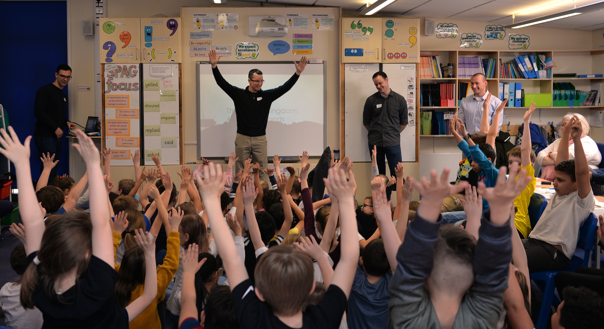 U.S. Air Force Airmen from RAF Mildenhall answer questions from children during a visit to Beck Row Primary Academy, Suffolk, England, March 29, 2019. Airmen RAF Mildenhall gave presentations and talked to students about a variety of differences between the United Kingdom and United States. Topics included animals, national parks, the U.S. President and the Queen. The school children are currently learning about the United States of America, and the RAF Mildenhall Airmen visited them to answer questions and give a better insight on the subject. (U.S. Air Force photo by Karen Abeyasekere)