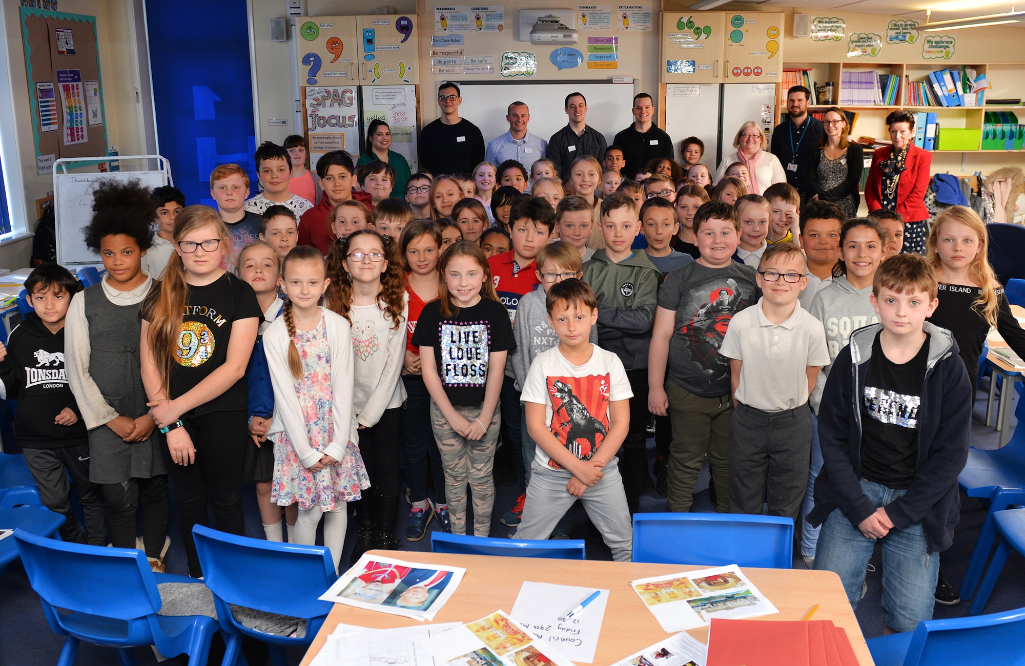 U.S. Airmen from RAF Mildenhall pose for a group photo with children and staff during a visit to Beck Row Primary Academy, Suffolk, England, March 29, 2019. The school children are currently learning about the United States of America, and the RAF Mildenhall Airmen visited them to answer questions and give a better insight on the subject. (U.S. Air Force photo by Karen Abeyasekere)