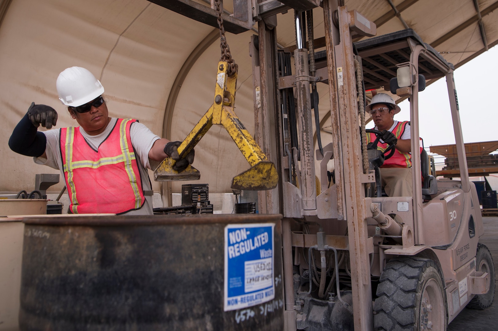 Marino Menor, left, 379th Expeditionary Civil Engineer Squadron (ECES) lead environmental technician, and Ramon Gonzales, 379th ECES environmental technician, prepare to ventilate an oil drum to ensure the barrel is safe for handling March 26, 2019, at Al Udeid Air Base, Qatar. The ECES environmental team ensures Airmen on base are able to safely handle hazardous material (HAZMAT) in an environmentally friendly manner. (U.S. Air Force photo by Tech. Sgt. Christopher Hubenthal)