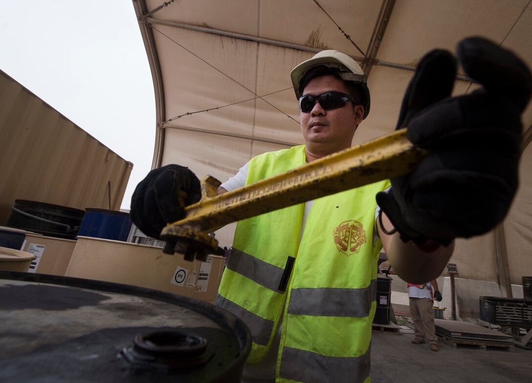 John Reyes, 379th Expeditionary Civil Engineer Squadron (ECES) environmental technician, releases pressure from an oil drum March 26, 2019, at Al Udeid Air Base, Qatar. Recyclable items such as glass and plastic bottles that are thrown in trash dumpsters at Al Udeid are sorted and recycled at locations off the installation. (U.S. Air Force photo by Tech. Sgt. Christopher Hubenthal)