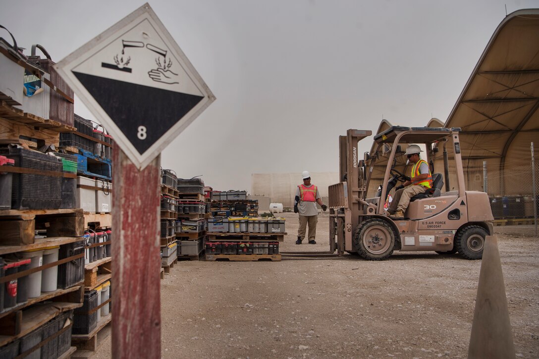 Marino Menor, left, 379th Expeditionary Civil Engineer Squadron (ECES) lead environmental technician, guides Jerome Pineda, 379th ECES environmental technician, as he operates a forklift March 26, 2019, at Al Udeid Air Base, Qatar. Recyclable items such as glass and plastic bottles that are thrown in trash dumpsters at Al Udeid are sorted and recycled at locations off the installation. (U.S. Air Force photo by Tech. Sgt. Christopher Hubenthal)