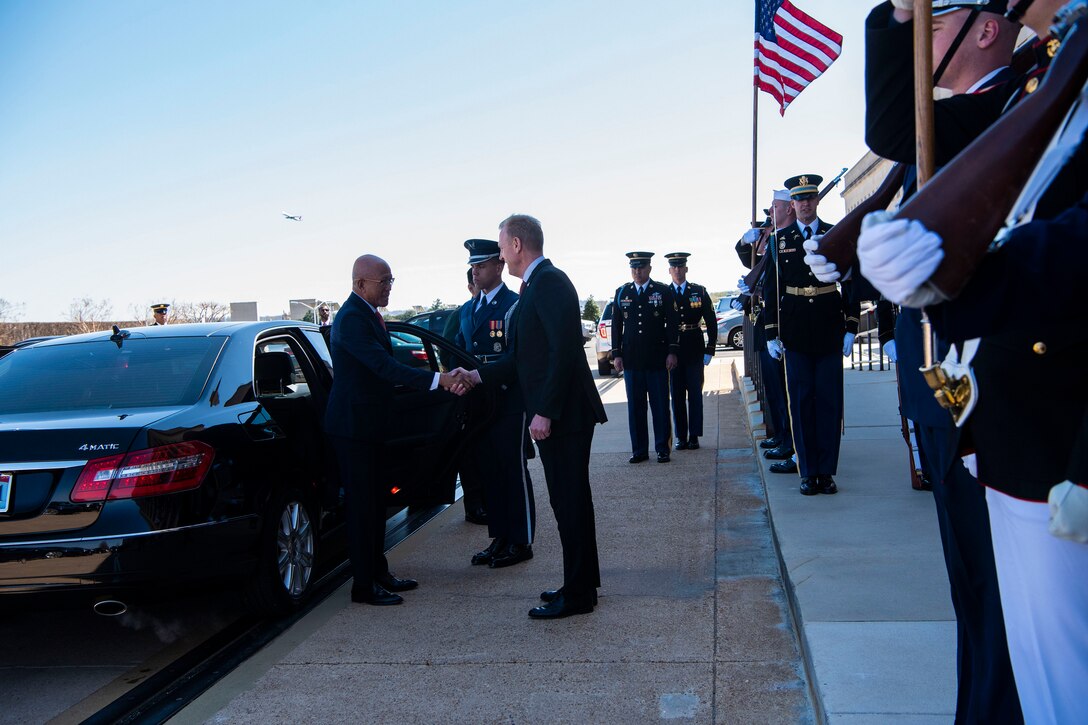 Two defense leaders shake hands outside the Pentagon.