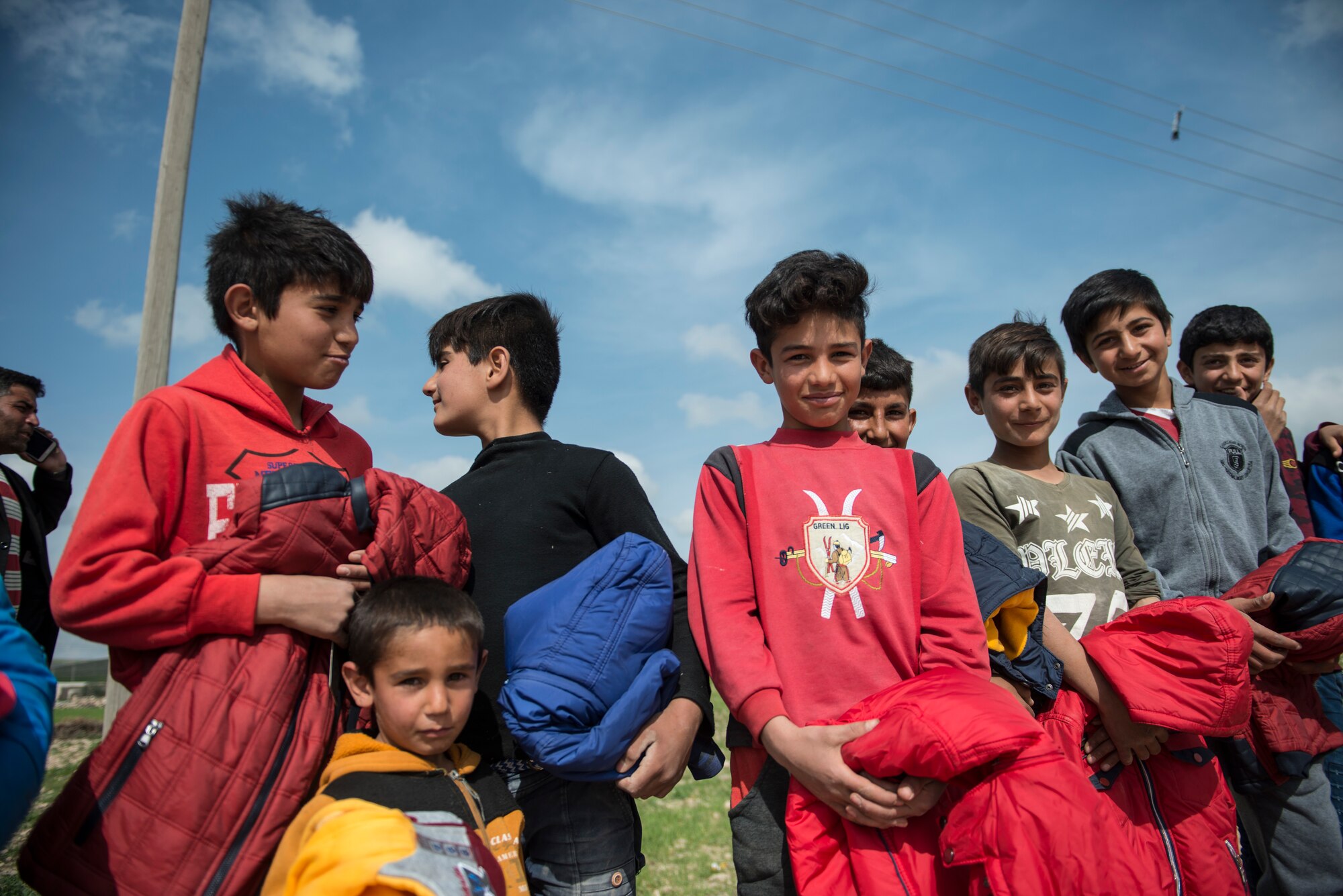 Children smile as they hold jackets they received from U.S. military personnel March 12, 2019, Southwest Asia. Families in the area have gone without essential items due to the violent conflicts in the area. (U.S. Air Force photo by Staff Sgt. Malissa Armstrong)
