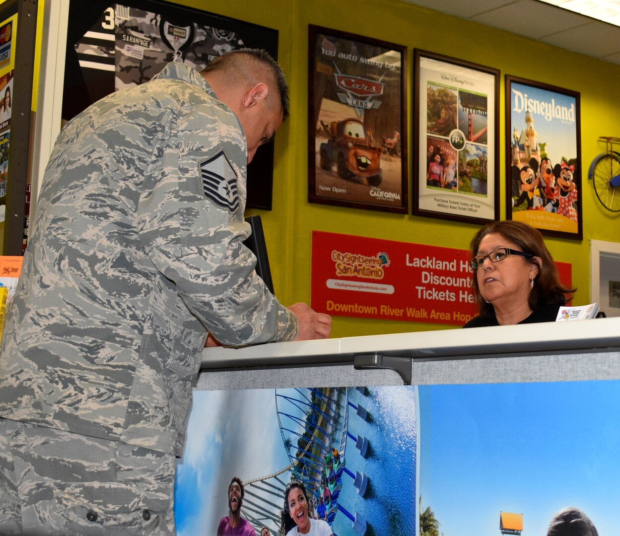 Diana Gonzalez, Joint Base San Antonio-Lackland's Information, Tickets and Travel Office sales associate, helps Master Sgt. Juan Rodriguez, a 26th Aerial Port Squadron member, select seats for a sporting event.