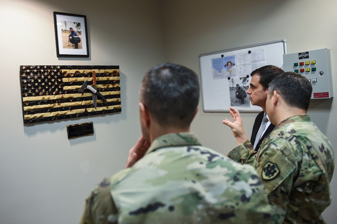 A photo of Scott Wirtz and a handcrafted flag adorn the wall in the Strategic Expeditionary Group and Global Security Division building in San Antonio, Texas. Wirtz, a DIA civilian, was killed during a terrorist attack in January.