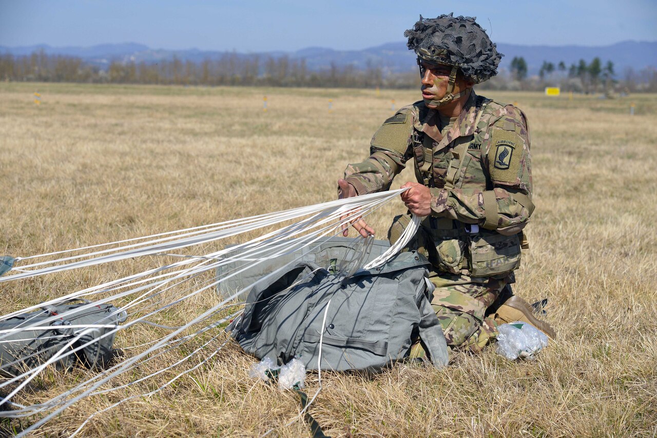 A paratrooper secures his equipment after a jump.