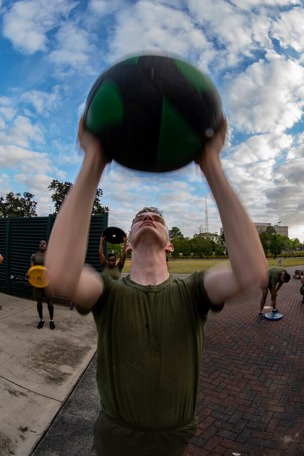 Lance Cpl. Hunter Breedlove, a maintenance management clerk with 4th Marine Logistics Group, Marine Forces Reserve conducts medicine ball lifts at Marine Corps Support Facility New Orleans, March 29, 2019, during a Total Force Fitness event. The MARFORRES Marines conducted various physical activities, such as tug-of-war, buddy carries, high-intensity suicide drills, medicine ball exercises and the dissemble and assembly of a M4 Service Carbine. The event promoted physical fitness, unit cohesion and esprit de corps. (U.S. Marine Corps photo by Sgt. Andy O. Martinez)