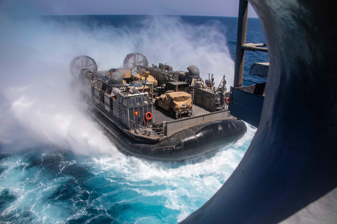 An air-cushioned landing craft moving through water.