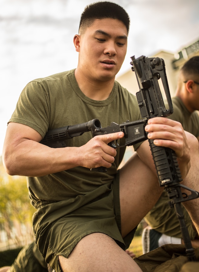 Cpl. Patrick Y. Chok, financial management analyst with the comptroller office, Marine Forces Reserve, disassembles a M16 service rifle during a Total Force Fitness event at Marine Corps Support Facility New Orleans, March 29, 2019. The purpose of the event was to boost unit cohesion, morale and maintain high physical fitness standards. (U.S. Marine Corps photo by Sgt. Dante J. Fries)