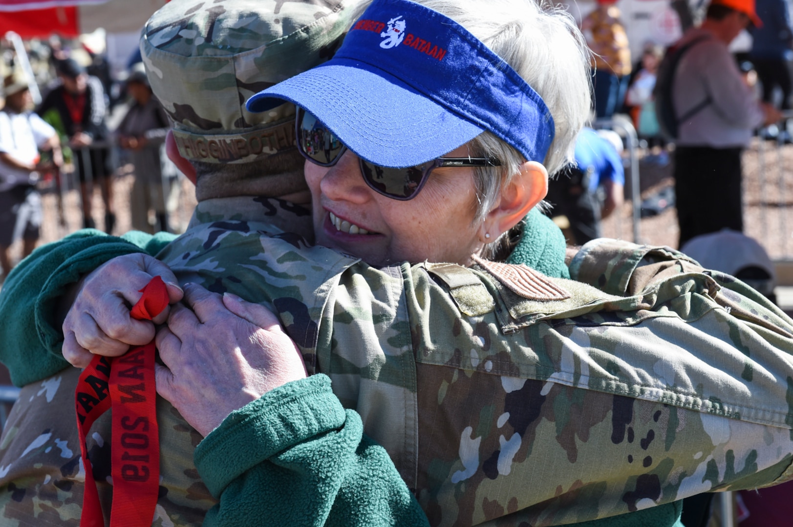 Beth Bania hugs Chief Master Sgt. Benjamin Higginbotham after DIA's command senior enlisted leader presented her with the medal he received for completing the 2019 Bataan Memorial Death March, March 17. Beth, and her sister Kay, drove all the way from Michigan to attend their first march and to finally meet Higginbotham, who has honored their father each of the last four years.