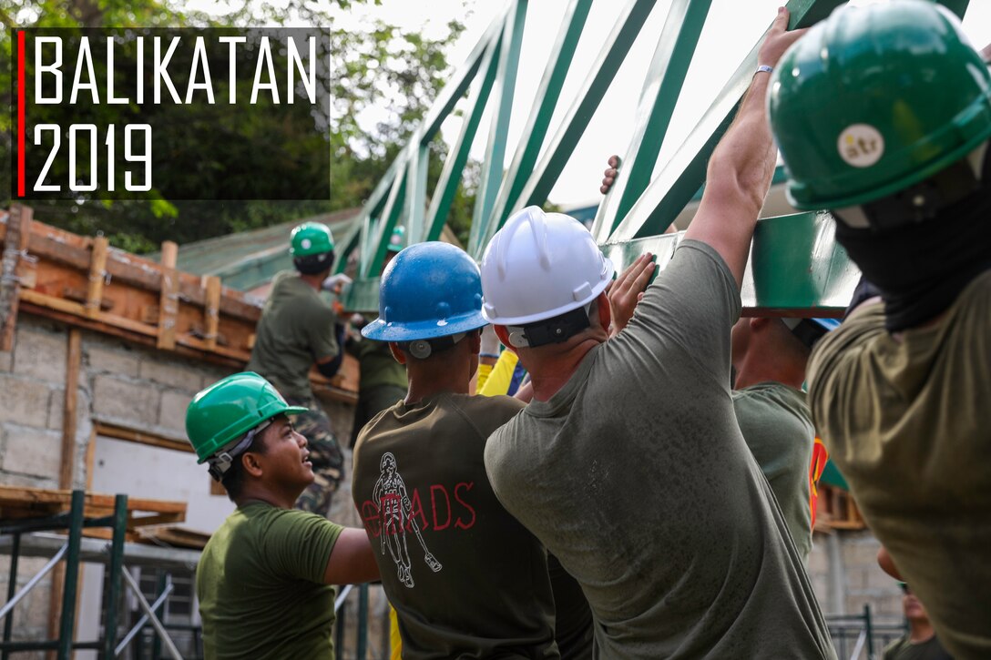 U.S. Marines and Philippine service members lift a steel roof truss into position at Victor O' De Guia Jr. Memorial Elementary School in Balian, Pangil, Laguna, Philippines, March 27, 2019, as part of Exercise Balikatan. Marines with Engineer Company A, 9th Engineer Support Battalion, 3rd Marine Logistics Group are working shoulder-to-shoulder with the Armed Forces of the Philippines and Australian Defence Force to build classrooms during Balikatan 2019. The exercise, in its 35th iteration, is an annual exercise between the U.S. military and the Armed Forces of the Philippines that allows the countries to strengthen relationships, increase interoperability, and improve the local community. (U.S. Marine Corps photo by Lance Cpl. Mark Fike)