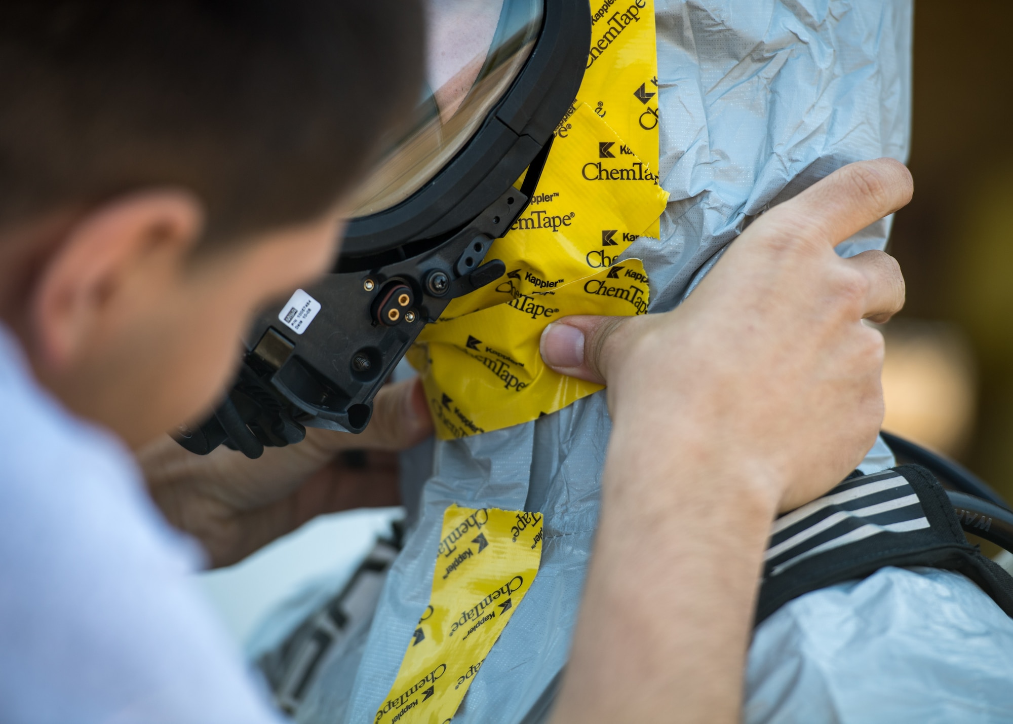 A U.S. Air Force Airman from the 633rd Aerospace Medicine Squadron bioenvironmental engineering flight applies chemtape to a wingman’s suit during an active chemical, biological, radiological and nuclear (CBRN) response training at Joint Base Langley-Eustis, Virginia, March 29, 2019.