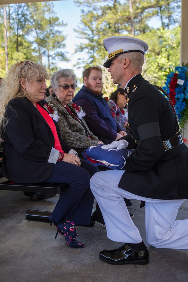 Col. Torrens G. Miller, commanding officer of Headquarters Battalion, Marine Forces Reserve, presents the flag to Jane B. Stegall, the spouse of retired Lt. Col Dennis Stegall during his funeral ceremony at Southeast Louisiana Veterans Cemetery on April 1, 2019. Stegall retired from the Marine Corps after 23 years of service in 2006 and continued to serve as the Marine Corps deputy comptroller for MARFORRES. (U.S. Marine Corps photo by Sgt. Dante J. Fries)