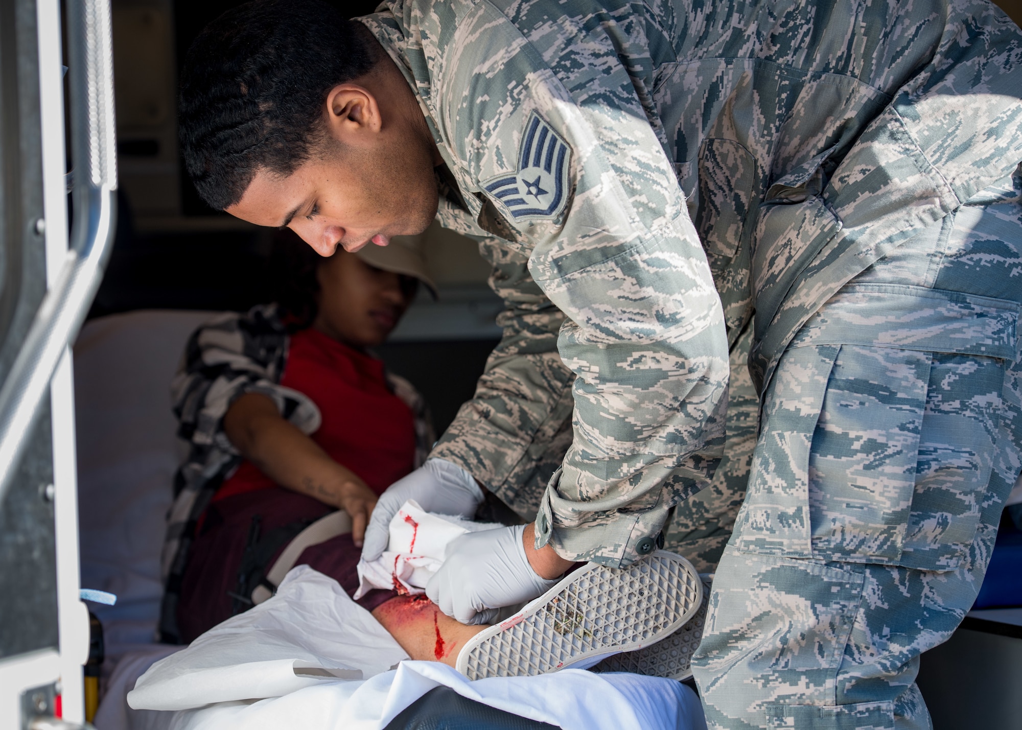 A U.S. Air Force Airman from the 633rd Medical Group tends to simulated wounds on a role-player’s leg during an active shooter exercise at Langley Air Force Base, Virginia, March 27, 2019.
