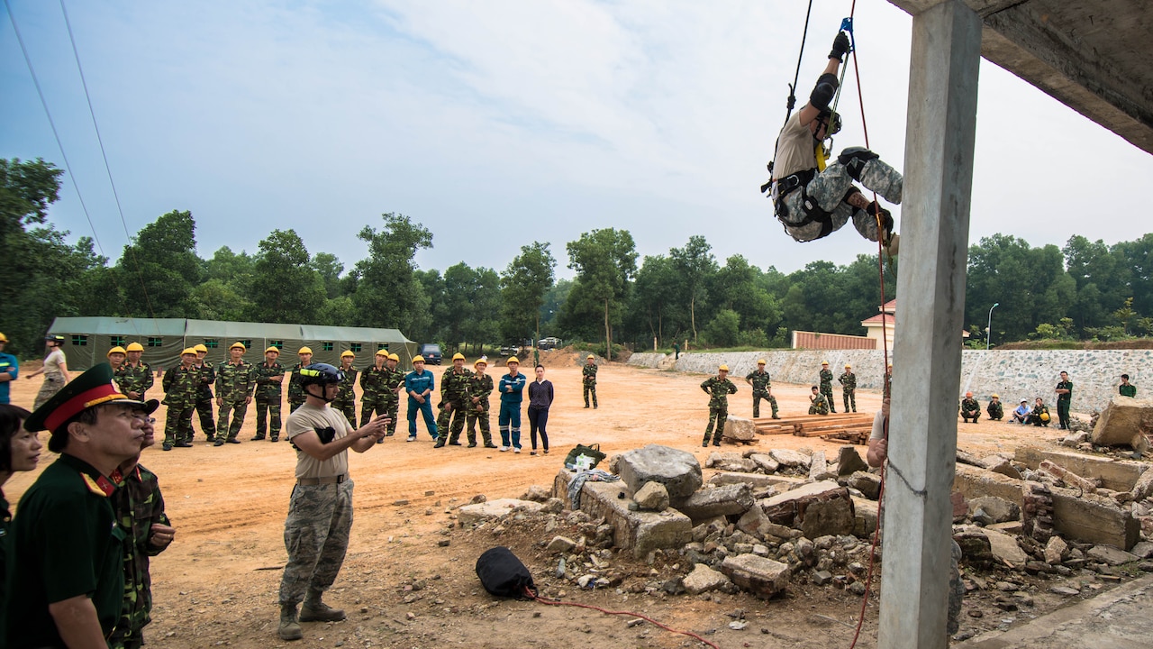 Soldier rappels as people watch.