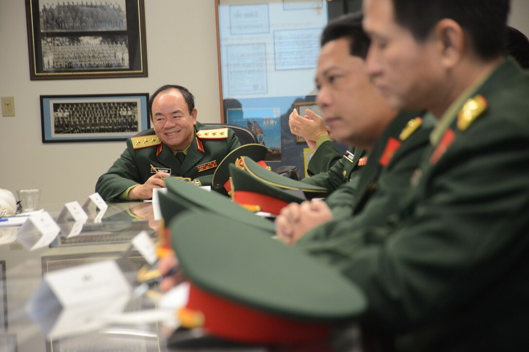 Vietnamese military personnel sit at a table.