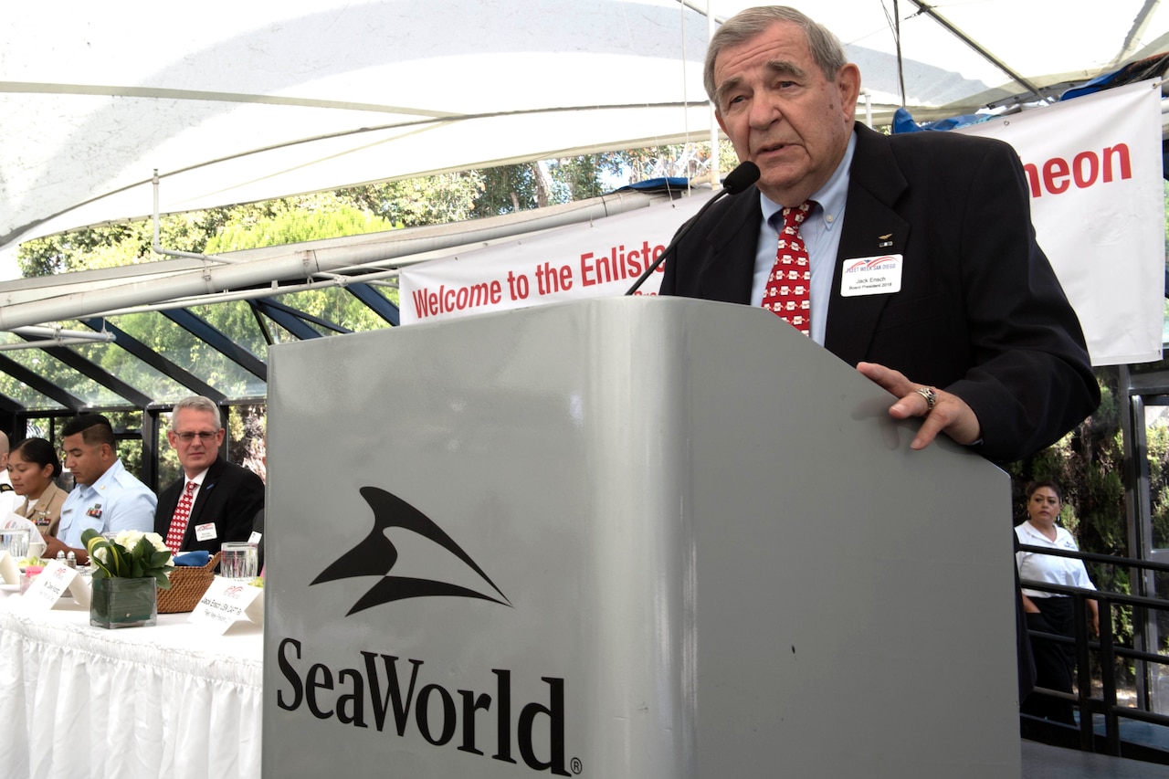 A man stands at a podium that reads "Sea World."