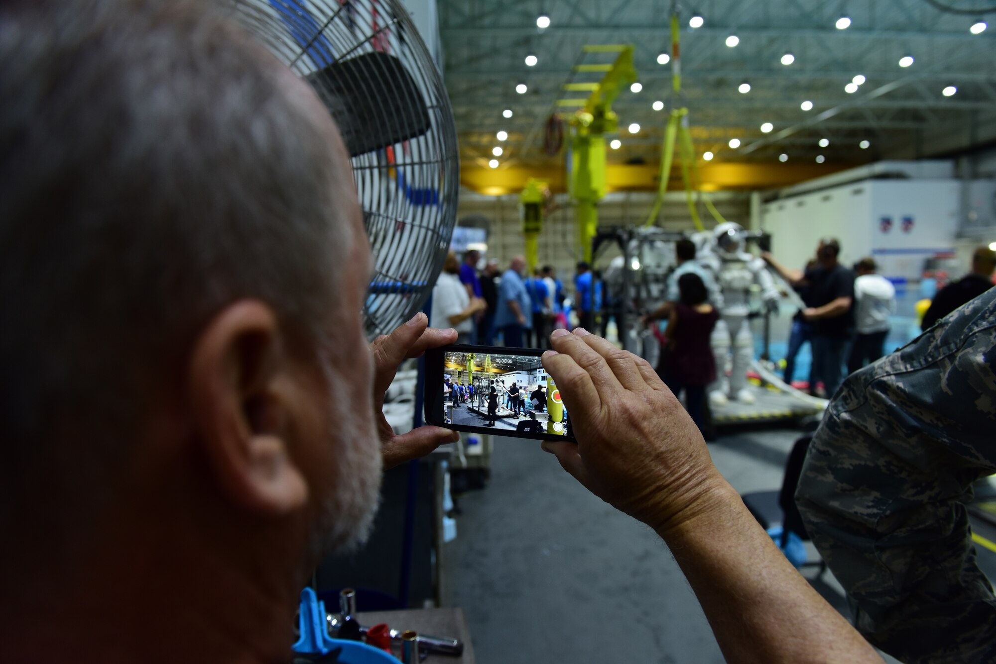 Tommy Sondag, 47th Operations Support Squadron aircrew flight equipment parachute technician, records an astronaut being extracted from NASA's Neutral Buoyancy Lab pool at Ellington Airport, Texas, March 26, 2019. Sondag visited NASA's Aircraft Operations T-38 life support to assist in the newly revamped T-38 parachute packing procedures. During his visit, he was given a tour of the NASA facilities in the area. (U.S. Air Force photo by Senior Airman Benjamin N. Valmoja)