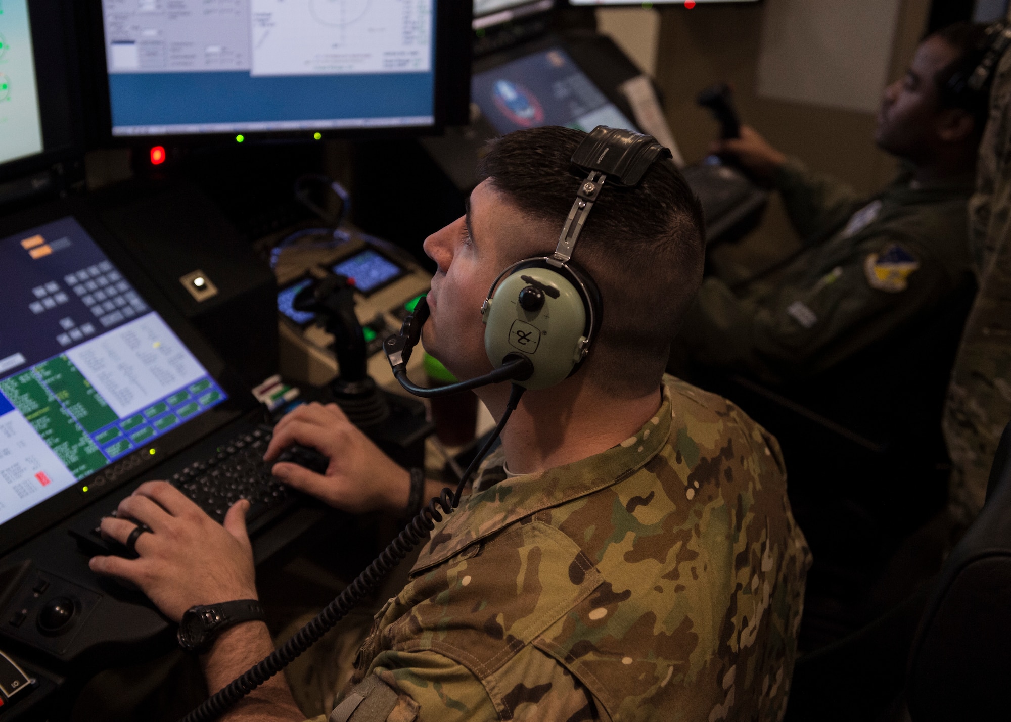 Capt. Joey (left), 6th Attack Squadron MQ-9 Reaper evaluator pilot, and Tech Sgt. Nicholas (right), 6th ATKS MQ-9 sensor operator instructor, simulate an exercise, March 13, 2019, at the 16th Training Squadron on Holloman Air Force Base, N.M. Holloman hosted 351st Special Warfare Training Squadron combat rescue officer students from Kirtland Air Force Base, N.M., March 12-14. (U.S. Air Force photo by Airman 1st Class Kindra Stewart)