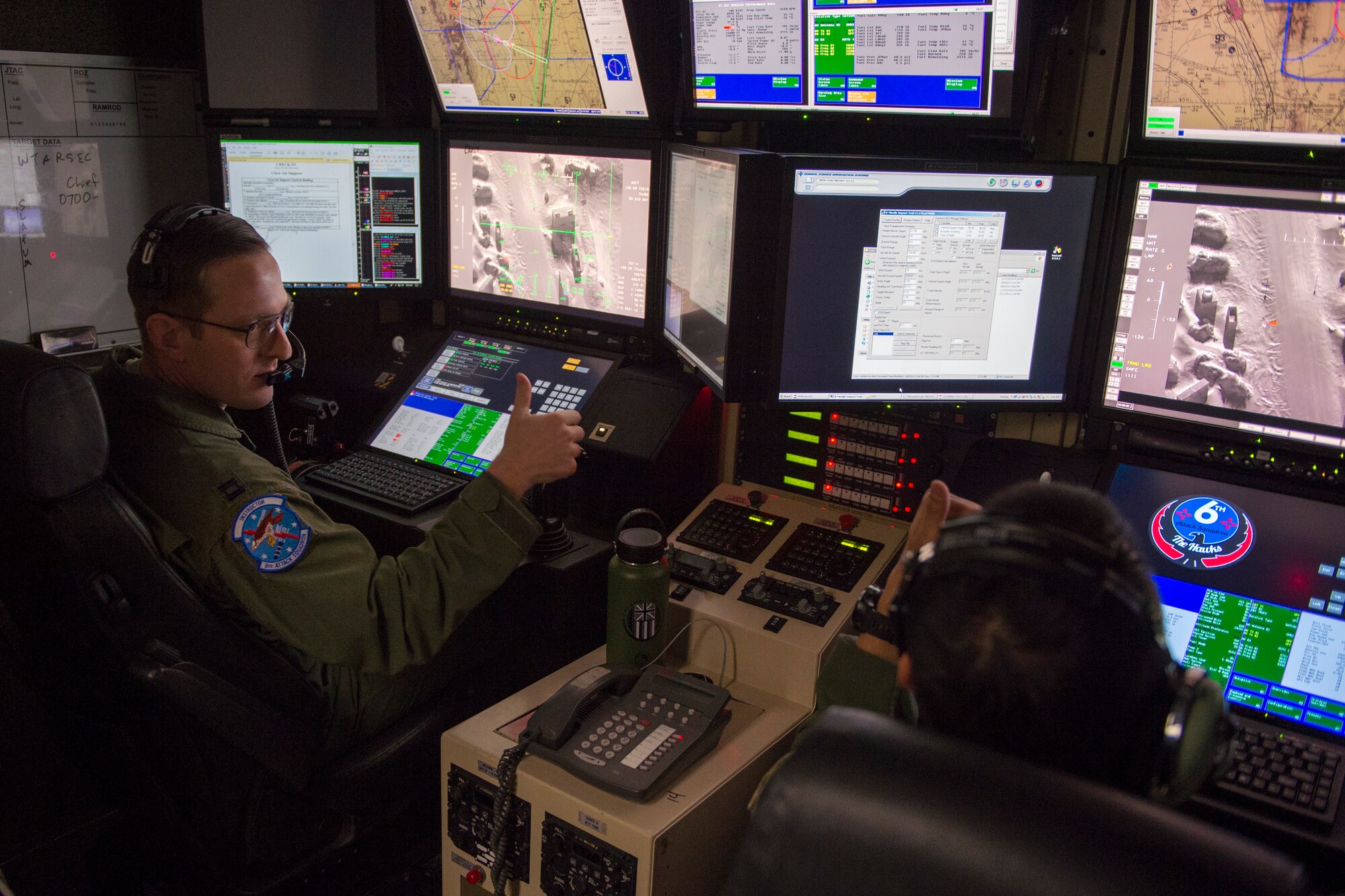 Capt. David (left), 6th Attack Squadron MQ-9 Reaper pilot, and  Tech. Sgt. Joaquin, 6th Attack Squadron MQ-9 Reaper sensor operator instructor, provide close air support over Red Rio Range, N.M., during an exercise, March 14, 2019, at the 6th Attack Squadron on Holloman Air Force Base, N.M. During the exercise, combat rescue officer students applied their training in a simulated deployed environment on Red Rio Range, N.M., by communicating with an actual MQ-9 overhead. (U.S. Air Force photo by Airman 1st Class Kindra Stewart)