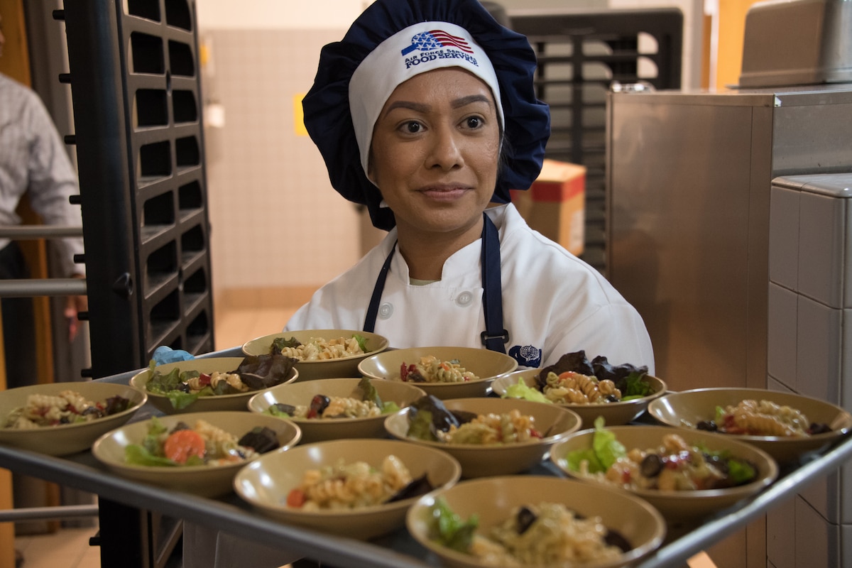 U.S. Air National Guardsman Airman 1st Class Gabriela Gutierrez from the 146th Airlift Wing Services Flight prepares food to be served during an evaluation at the Channel Islands Air National Guard Station, Port Hueneme, Calif., Mar. 9, 2019. The 146th Airlift Wing was selected out of 70 other wings for evaluation of kitchen operations for the possibility to win the Kenneth Disney award sponsored by the National Restaurant Association, the Culinary Institute of America and various hospitality industry sponsors for outstanding Air National Guard facilities with best dining operations nationally.  (U.S. Air National Guard photo by Tech. Sgt. Nieko Carzis.)