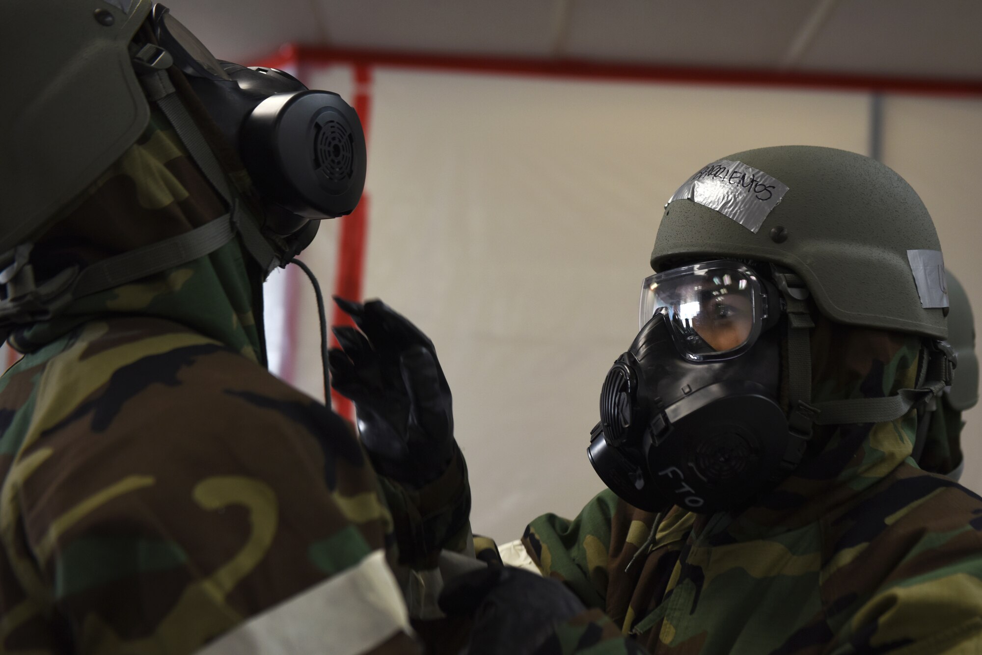 Airmen first class Adrianna Barrientos, right, and Jonathan Valdes Montijo use the buddy system to don Mission Oriented Protective Posture gear during Polar Force 19-4 at Joint Base Elmendorf-Richardson, Alaska, April 2, 2019. The exercise is made up of a variety of scenarios which test the arctic warriors' ability to handle real world situations. Barrientos and Valdes are both assigned to the 673d Air Base Wing Public Affairs.