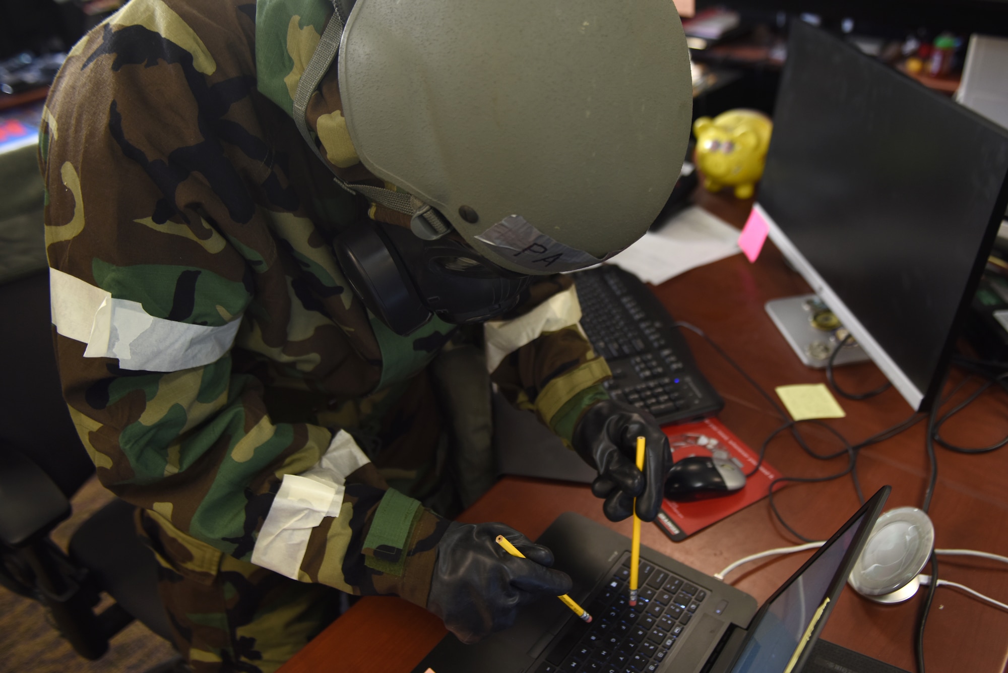 U.S. Air Force Airman 1st Class Jonathan Valdes, 673d Air Base Wing Public Affairs photojournalist, uses pencil erasers to type photo captions, while in Mission Oriented Protective Posture 4, during exercise Polar Force 19-4 at Joint Base Elmendorf-Richardson, Alaska, April 2, 2019. The exercise is made up of a variety of scenarios which test JBER’s ability to handle real world situations.