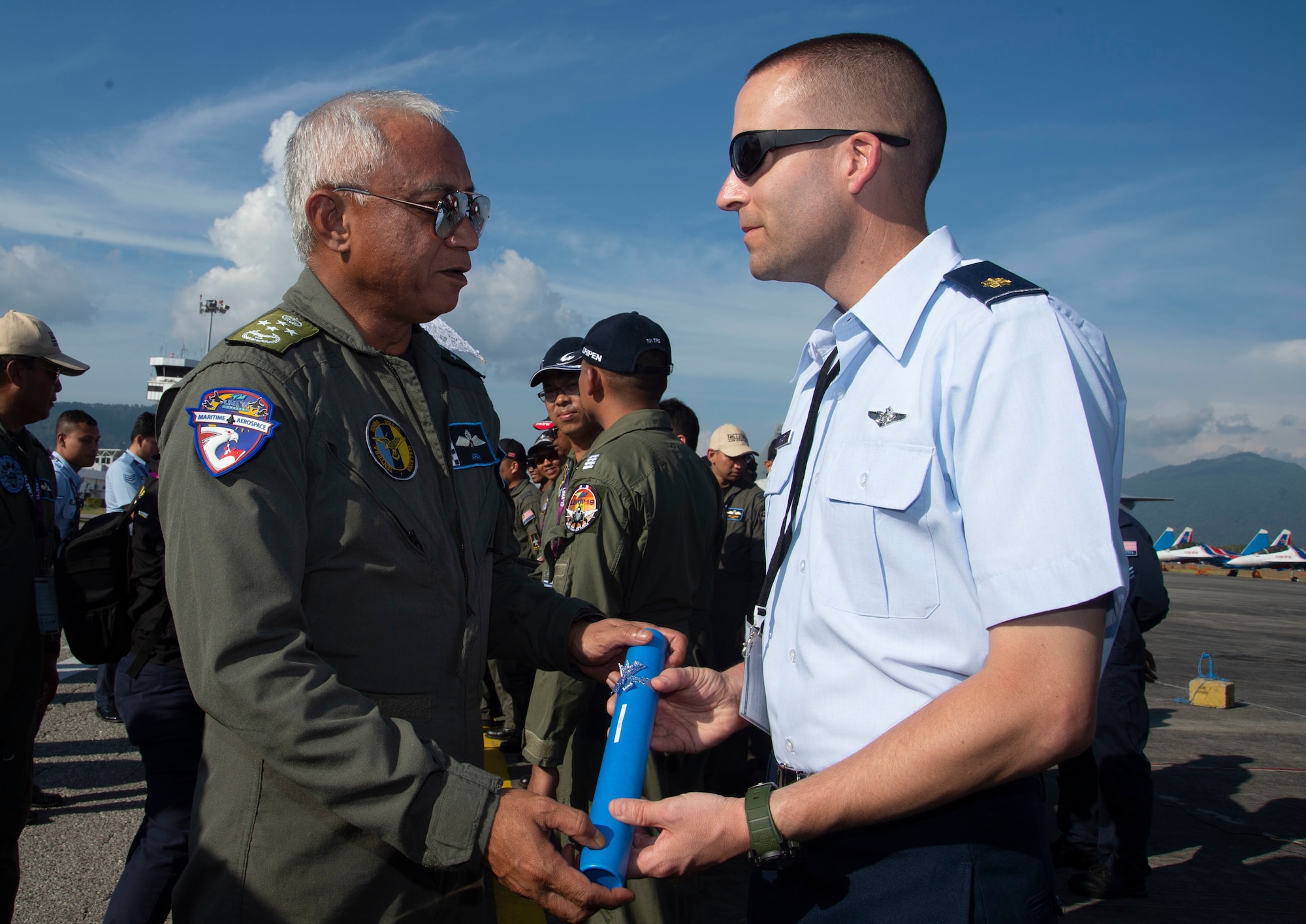 Malaysian Gen. Tan Sri Affendi Buang, Royal Malaysian Air Force chief, gives a certificate to U.S. Air Force Maj. Eric Myatt, assigned to U.S. Pacific Air Forces, Joint Base Pearl Harbor-Hickam, Hawaii, during an appreciation ceremony at the Langkawi International Maritime and Aerospace Exhibition 2019 in Padang Mat Sirat, Malaysia, March 29, 2019.