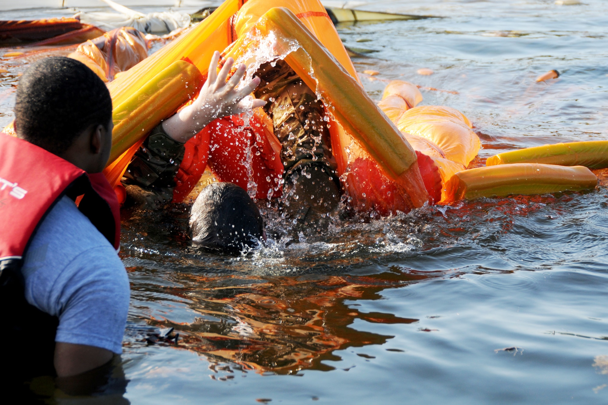 A member of the 94th Operations Group navigates under a parachute during Water Survival Training at Naval Air Station Key West, Florida March 27, 2019. During the water training members of the 94th Operations Group practiced on boarding one-man-rafts, maneuvering under a parachute, and mounting a 20-man life raft. (U.S. Air Force photo/Senior Airman Justin Clayvon)