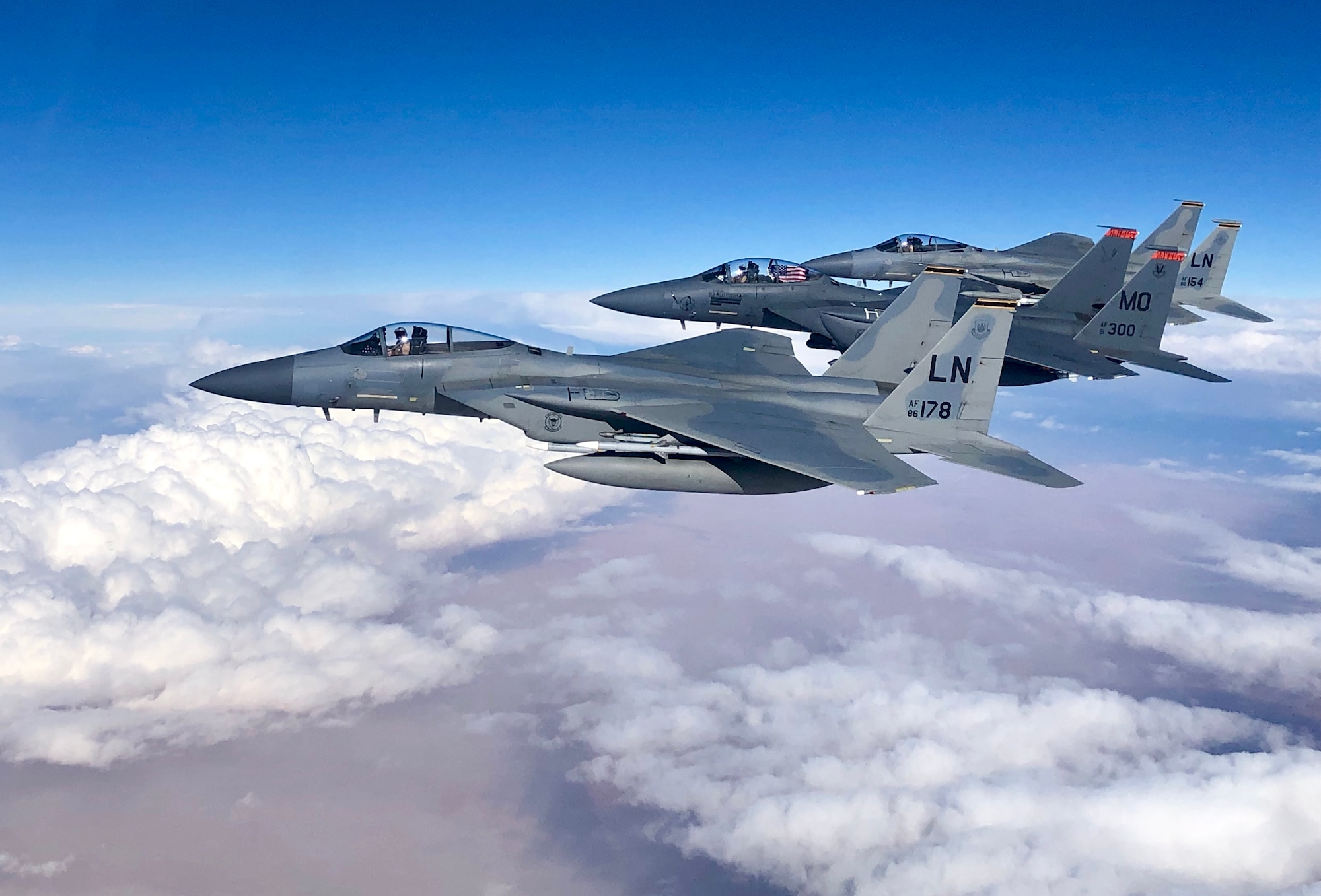 F-15C Eagles and an F-15E Strike Eagle fly over an undisclosed location in Southeast Asia in honor of the 493rd Fighter Squadron assumption of command for incoming commander Lt. Col. Anthony May during a mission supporting ongoing theater operations, February 28, 2019. The 493rd is a combat-ready squadron capable of executing air superiority and air defense missions in support of United States Air Forces in Europe, United States European Command, and NATO operations. (Courtesy photo)