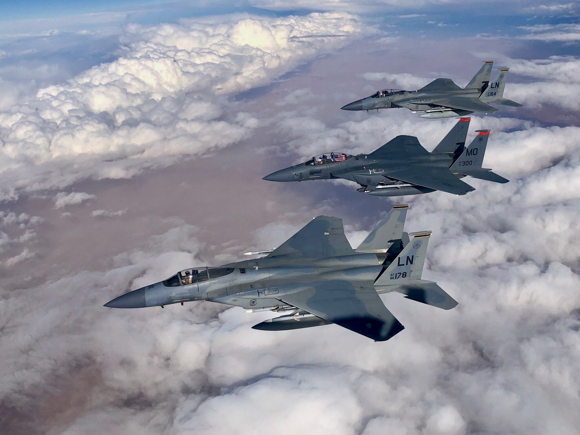 F-15C Eagles and an F-15E Strike Eagle fly over an undisclosed location in Southeast Asia in honor of the 493rd Fighter Squadron assumption of command for incoming commander Lt. Col. Anthony May during a mission supporting ongoing theater operations, February 28, 2019. The 493rd is a combat-ready squadron capable of executing air superiority and air defense missions in support of United States Air Forces in Europe, United States European Command, and NATO operations. (Courtesy photo)