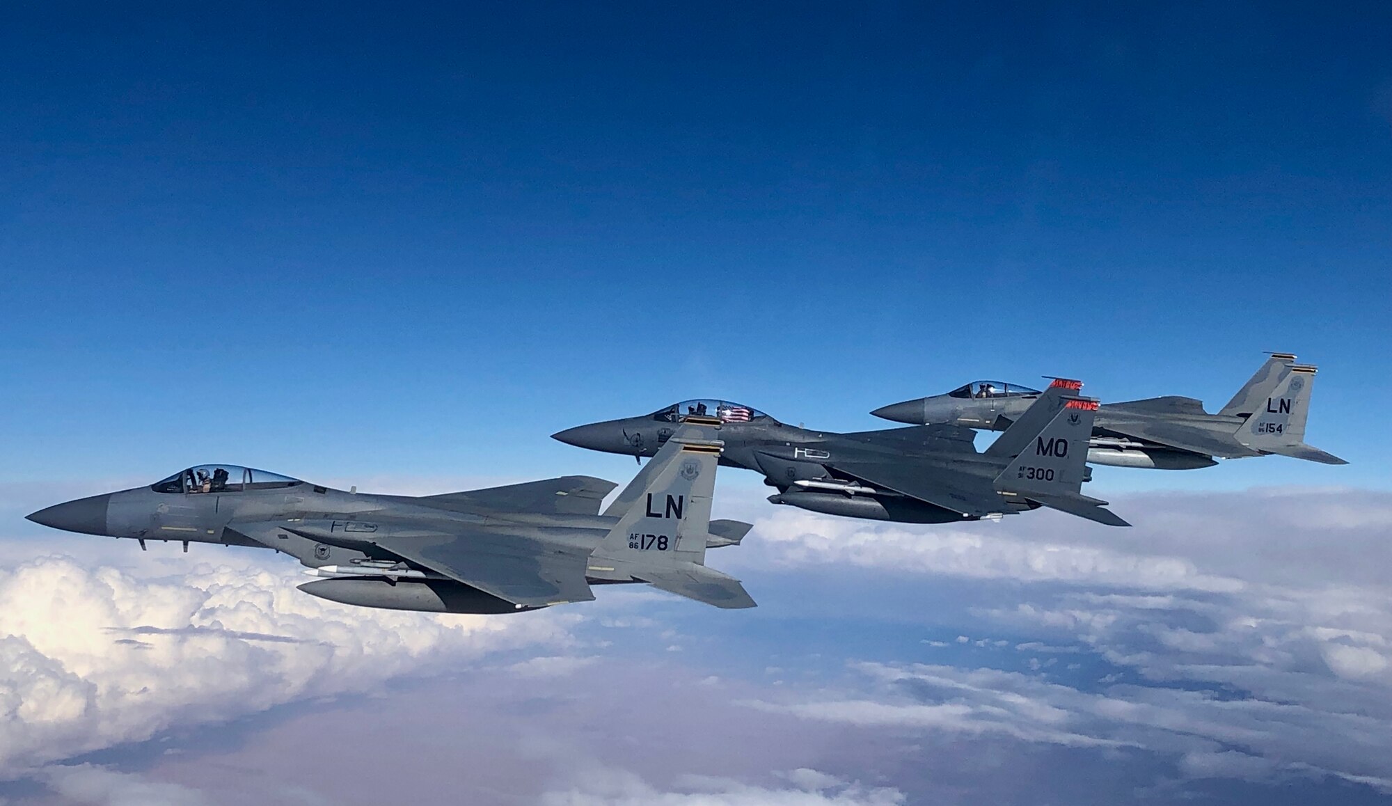 F-15C Eagles and an F-15E Strike Eagle fly over an undisclosed location in Southeast Asia in honor of the 493rd Fighter Squadron assumption of command for incoming commander Lt. Col. Anthony May during a mission supporting ongoing theater operations, February 28, 2019. The 493rd is a combat-ready squadron capable of executing air superiority and air defense missions in support of United States Air Forces in Europe, United States European Command, and NATO operations. (Courtesy photo)