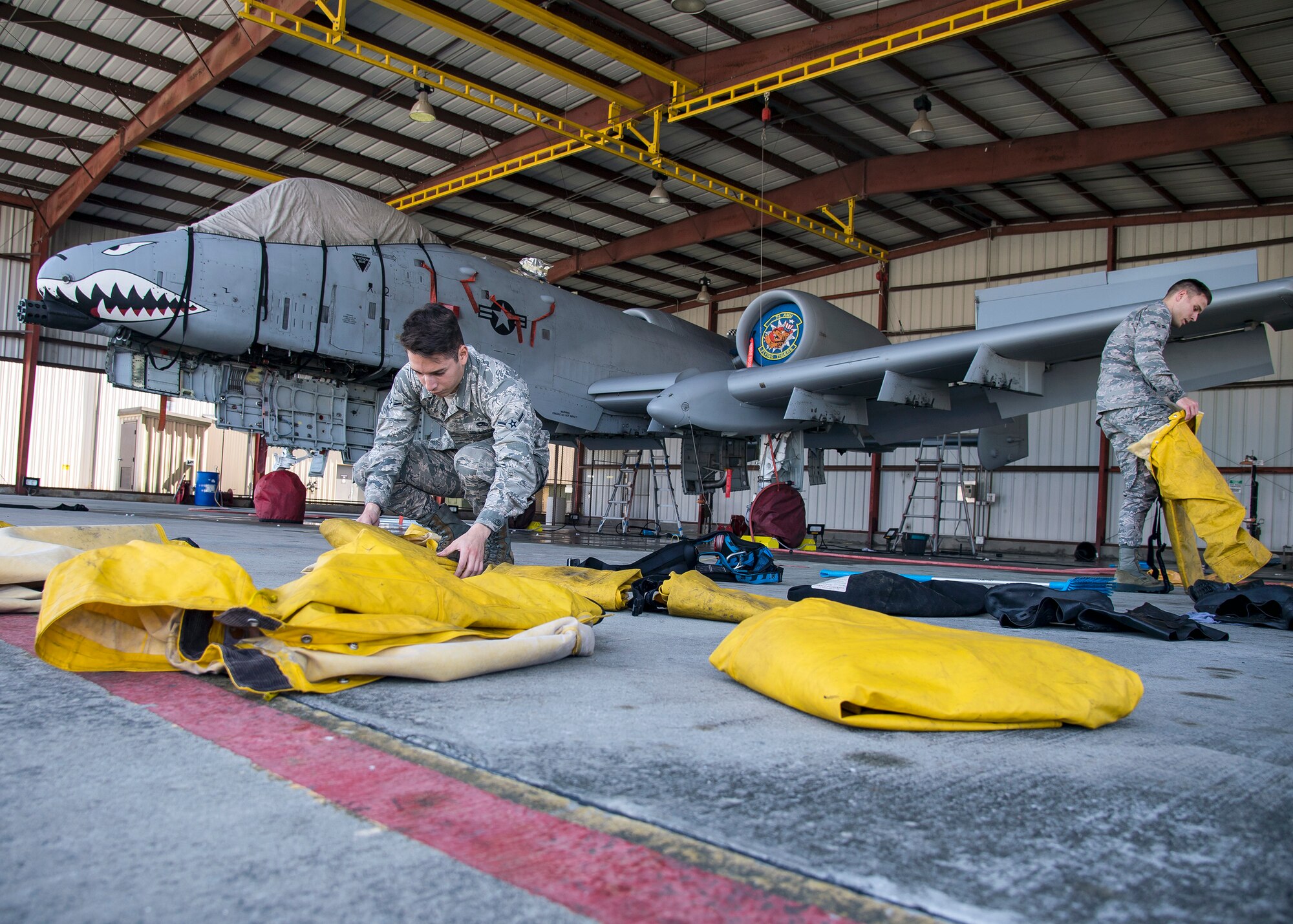Airmen from the 23d Maintenance Group put on personal protective equipment prior to an A-10C Thunderbolt II wash, Feb. 25, 2019, at Moody Air Force Base, Ga. On top of their daily scheduled maintenance a team of six Airmen dedicated over 10 hours washing the A-10 to ensure the aircraft was free of any surface or structural deficiencies that could present a safety hazard during flight. (U.S. Air Force photo by Airman 1st Class Eugene Oliver)