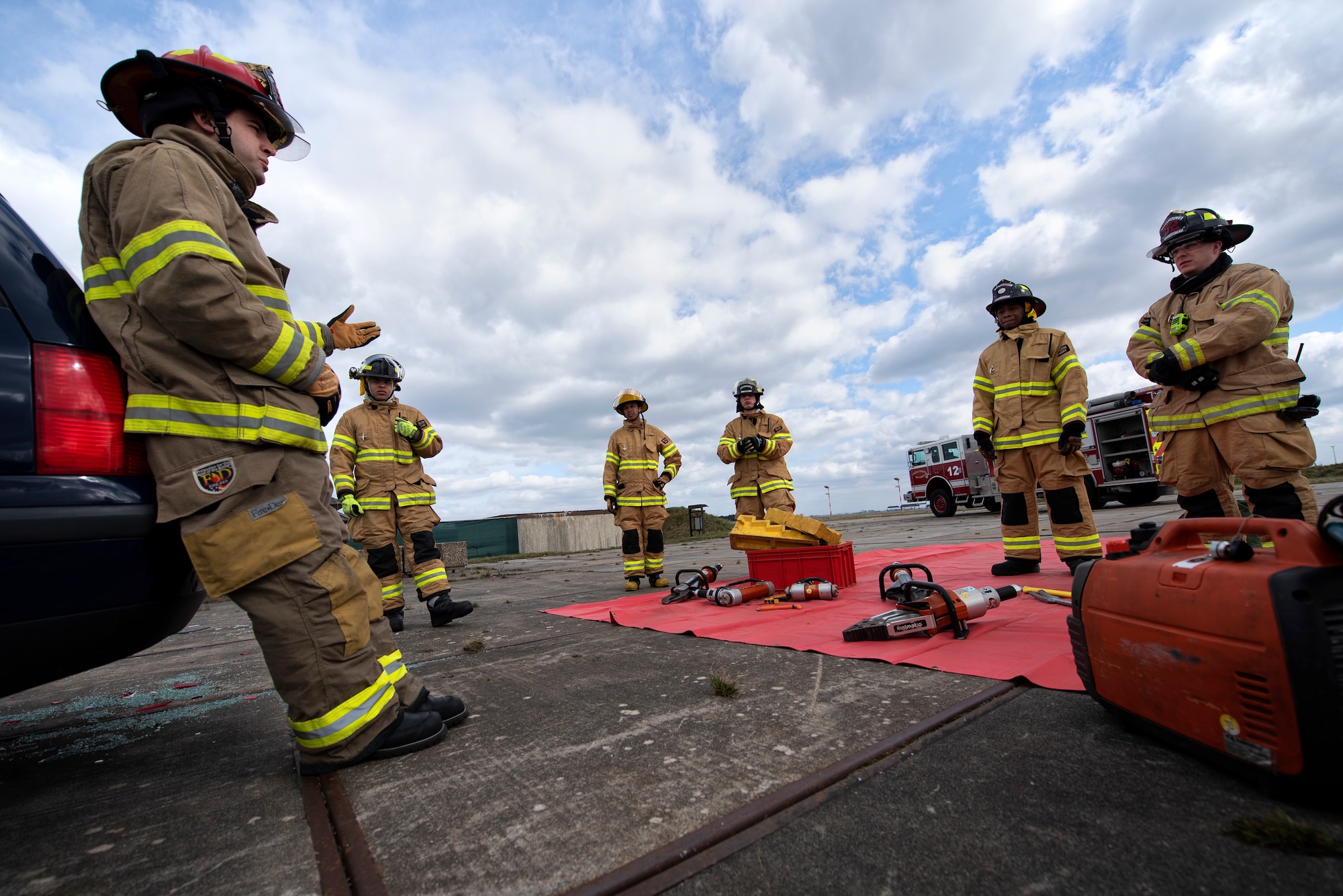 U.S. Air Force Tech. Sgt. Matthew Broussard, 52nd Civil Engineer Squadron fire prevention NCO in charge, left, briefs firefighters before a vehicle extrication exercise at Spangdahlem Air Base, Germany, March 26, 2019. This training helps firefighters learn how to effectively remove a victim out of a car that has been in an incident. (U.S. Air Force photo by Airman 1st Class Valerie Seelye)