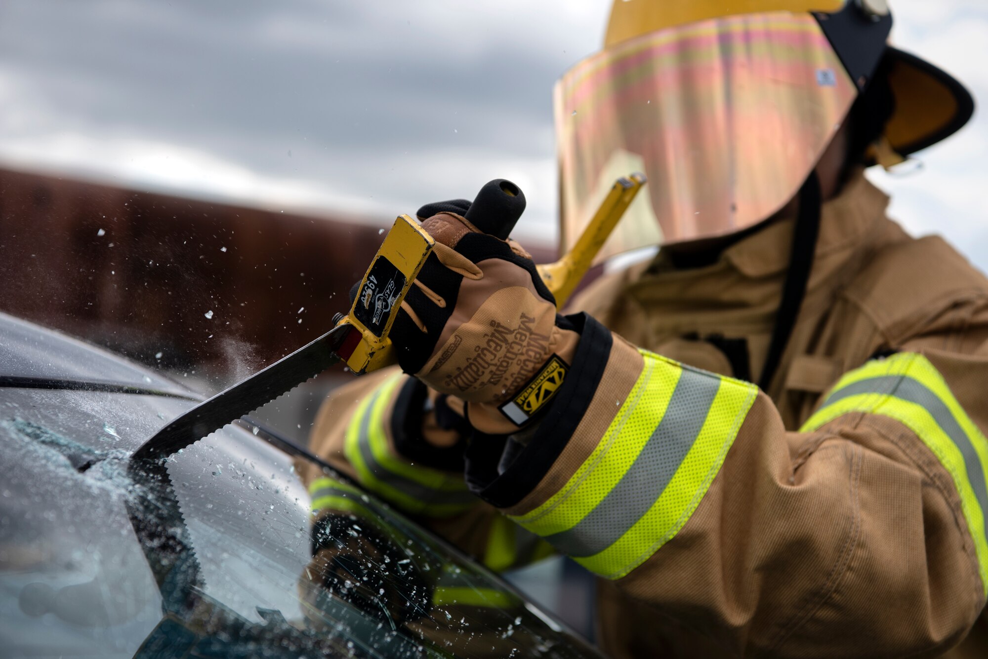 Omar Moylan, a senior at Spangdahlem High School, cuts through a windshield at Spangdahlem Air Base, Germany, March 26, 2019. Moylan, who plans on becoming a firefighter, participated in vehicle extrication training with the 52nd Civil Engineer Squadron Fire Department to gain real-life experience in his desired career field. (U.S. Air Force photo by Airman 1st Class Valerie Seelye)
