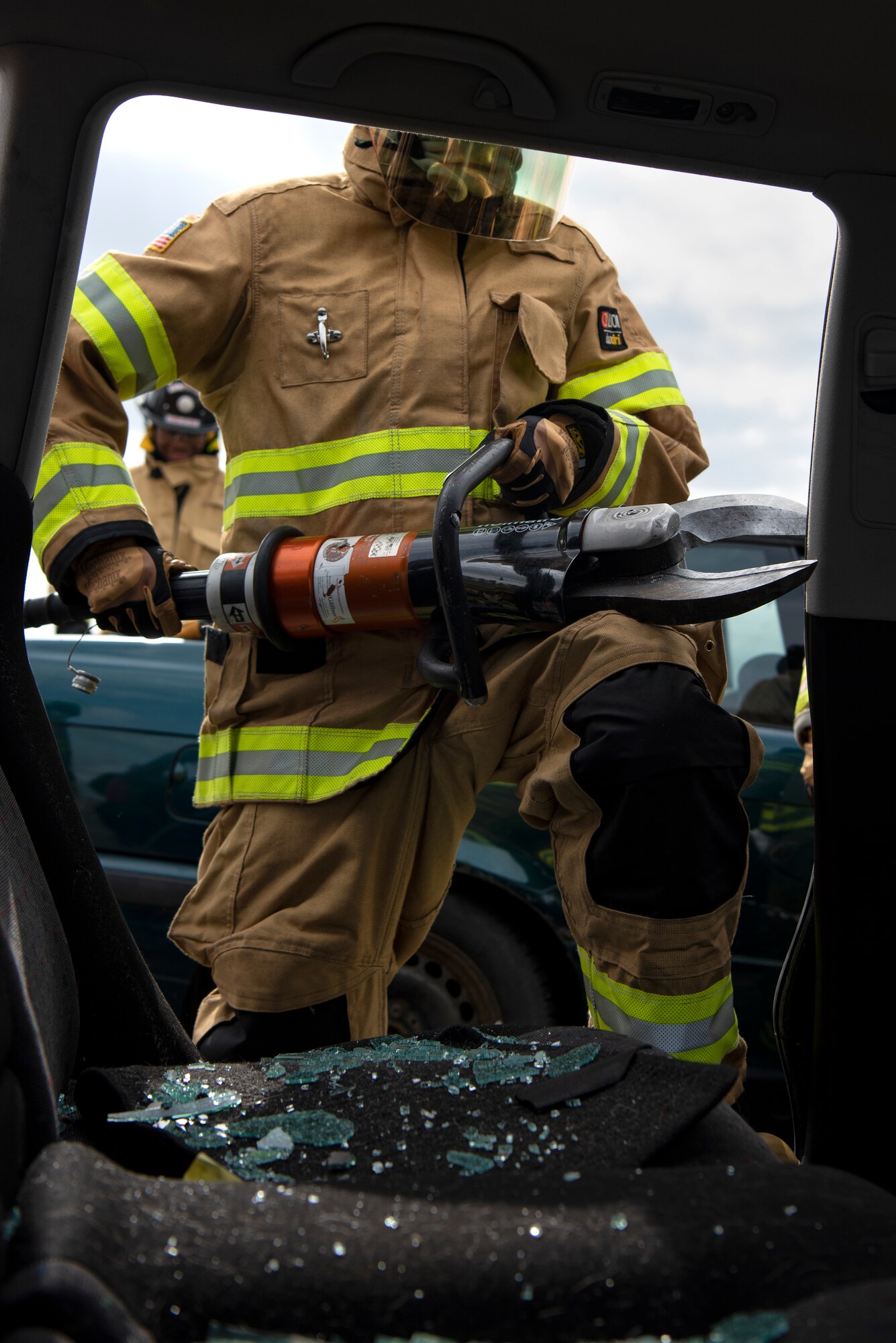 Omar Moylan, a senior at Spangdahlem High School, uses high-pressure hydraulic equipment to cut through posts on a car at Spangdahlem Air Base, Germany, March 26, 2019. Moylan participated in vehicle extrication training with the 52nd Civil Engineer Squadron Fire Department to learn how to quickly remove a person under medical distress from a car. (U.S. Air Force photo by Airman 1st Class Valerie Seelye)