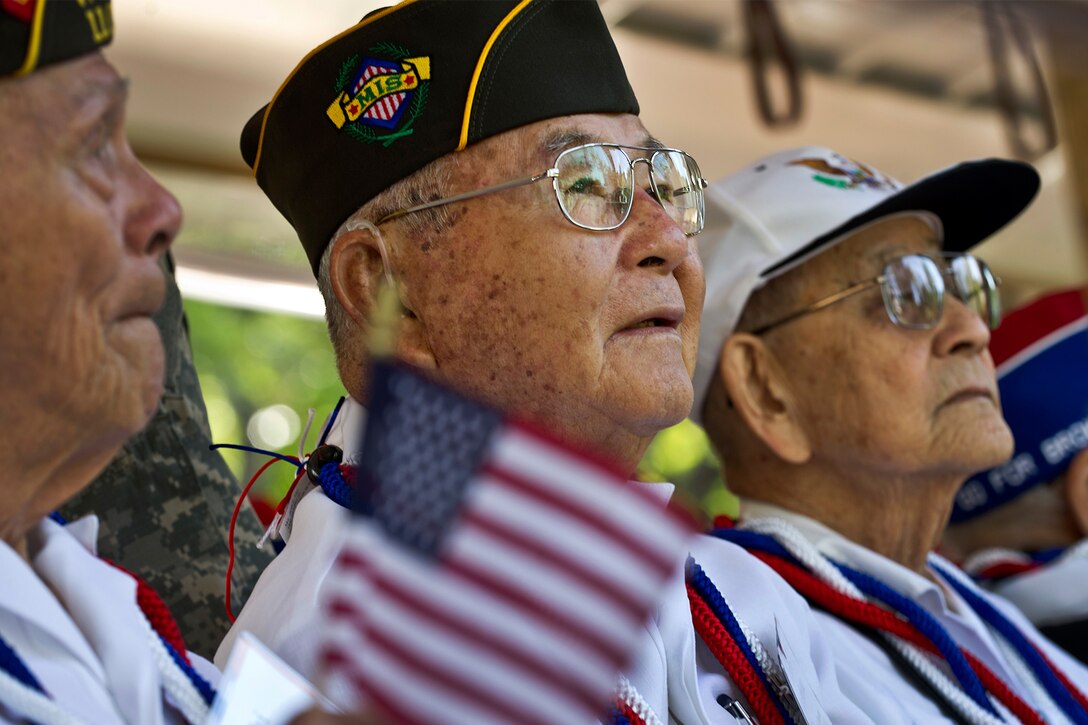 Three Japanese American World War II veterans look toward the distance.