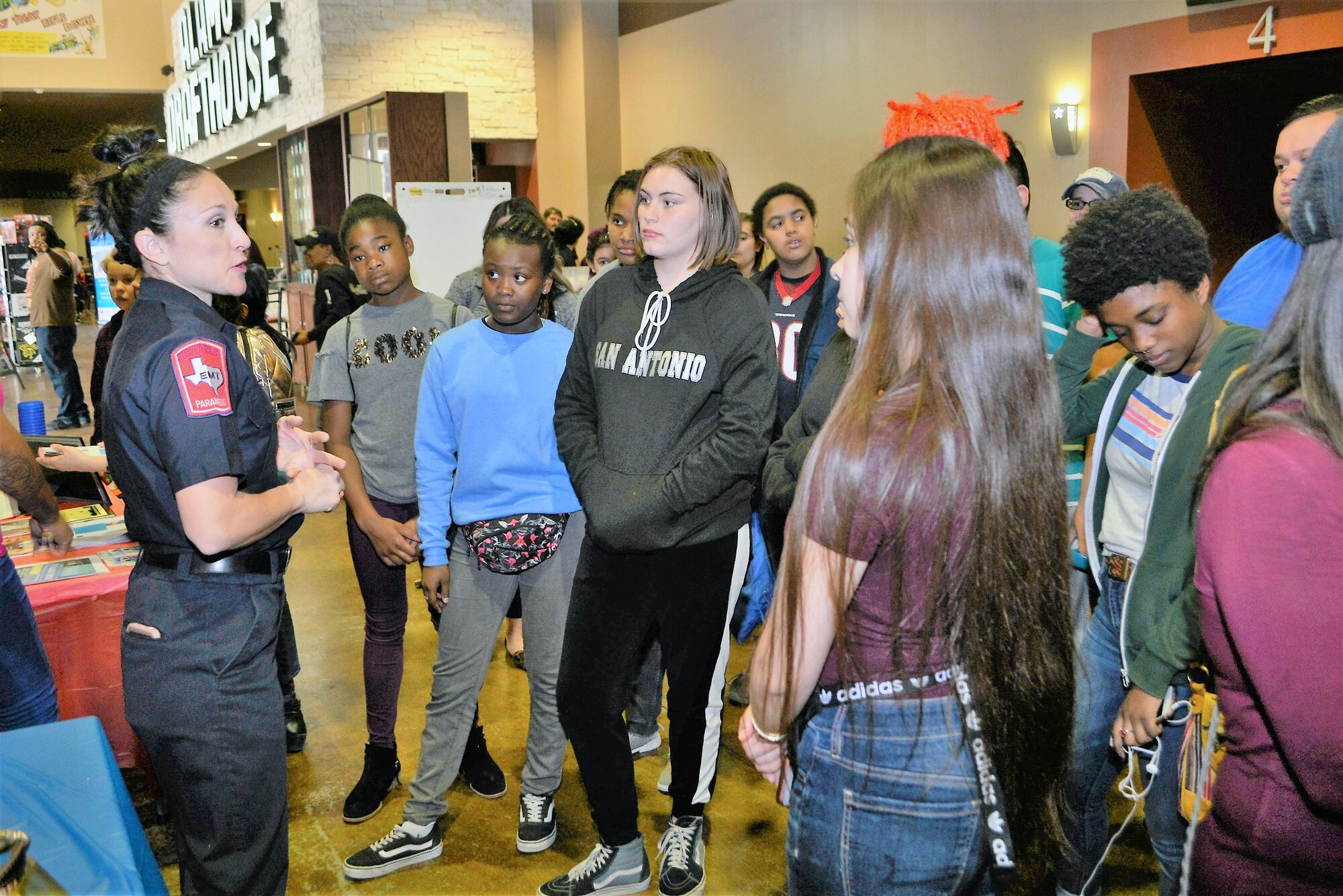 Dana Zamarripa, a firefighter/paramedic with the city of San Antonio, talks with a group of girls during the “Marvelous Women Don’t Need Capes,” event in the lobby of the Alamo Drafthouse movie cinema March 23, 2019.