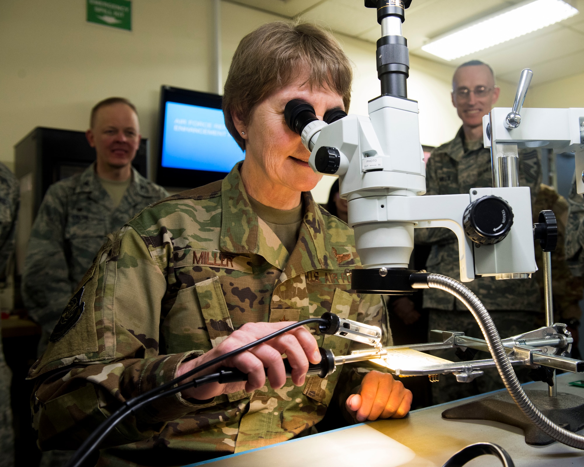 U.S. Air Force Gen. Maryanne Miller, Air Mobility Command commander, views a computer chip through a microscope in the Air Force Repair Enhancement Program office at Fairchild Air Force Base, Washington, March 27, 2019. A key message during Miller’s visit was the importance of adopting an innovative mindset and creating a culture that empowers Airmen to experiment and present solutions to problems. (U.S. Air Force photo by Airman 1st Class Lawrence Sena)