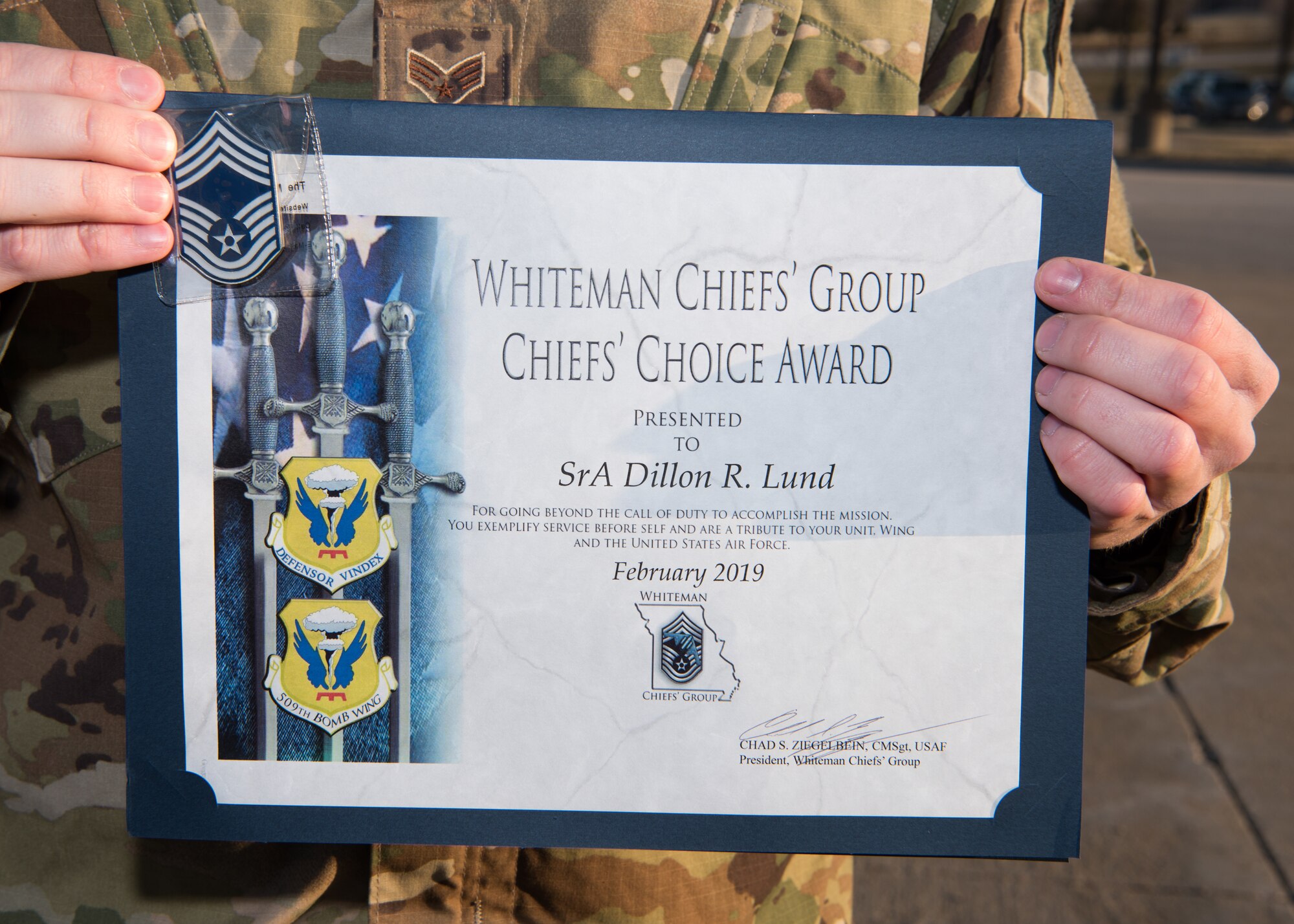 Senior Airman Dillon Lund holds up his Chief’s Choice Award and challenge coin on March 21, 2019.