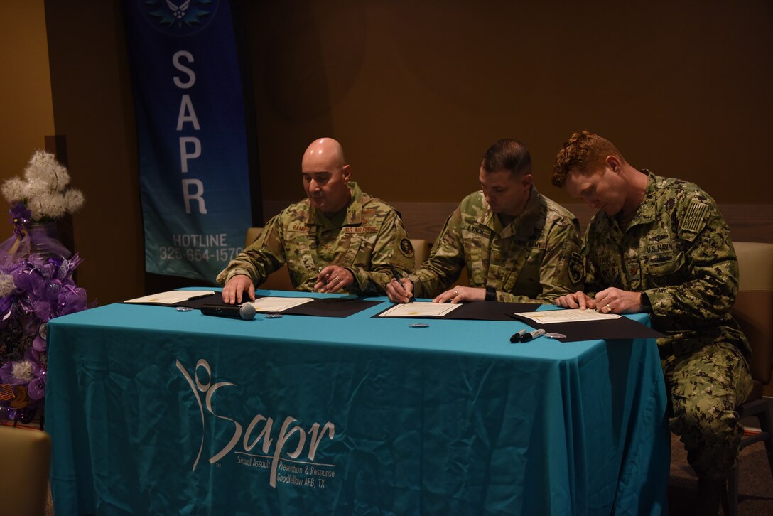 U.S. Air Force Col. Robert Ramirez, 17th Training Wing vice commander, U.S. Army Maj. Shawn Lynch, 344th Military Intelligence Battalion executive officer, and U.S. Navy Lt. Cmdr. J. Austin Maxwell, Navy Center for Information and Warfare Training Detachment commanding officer, sign the proclamation for the observances that will be held in April at the Western Winds Dining Facility on Goodfellow Air Force Base, Texas April 3, 2019. April is the Month of the Military Child, Child Abuse Prevention Month, Alcohol Awareness Month and Sexual Assault Awareness Month. (U.S. Air Force photo by Senior Airman Seraiah Hines/Released)