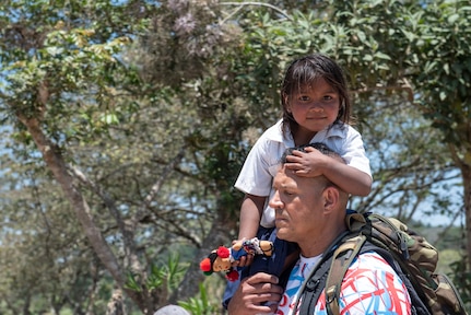 U.S. Army Lt. Col. Alex Duran, J3 Joint Operations Director, helps one of the local children on the trip down the mountain during Chapel Hike 78 in La Paz, Honduras, March 30, 2019.