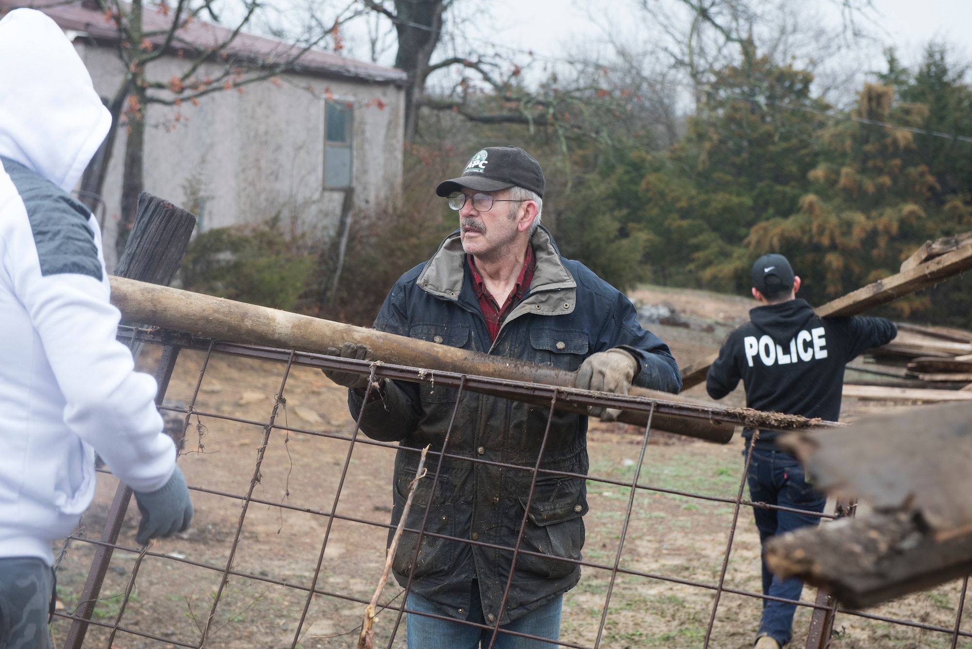 Vietnam War veteran Todd Conner takes a piece of scrap wood from a 509th Security Forces Airman on his Knob Noster, Missouri farm on March 30, 2019.