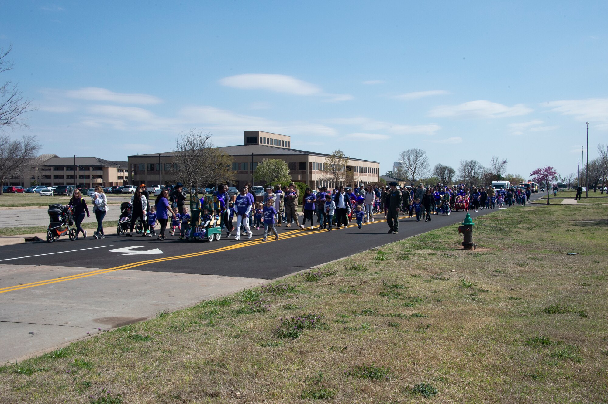 Members of the Month of the Military Child parade walk across the base, April 1, 2019, at Altus Air Force Base, Okla. Members across the base walked from Wings of Freedom Park to the youth center. (U.S. Air Force photo by Senior Airman Cody Dowell)
