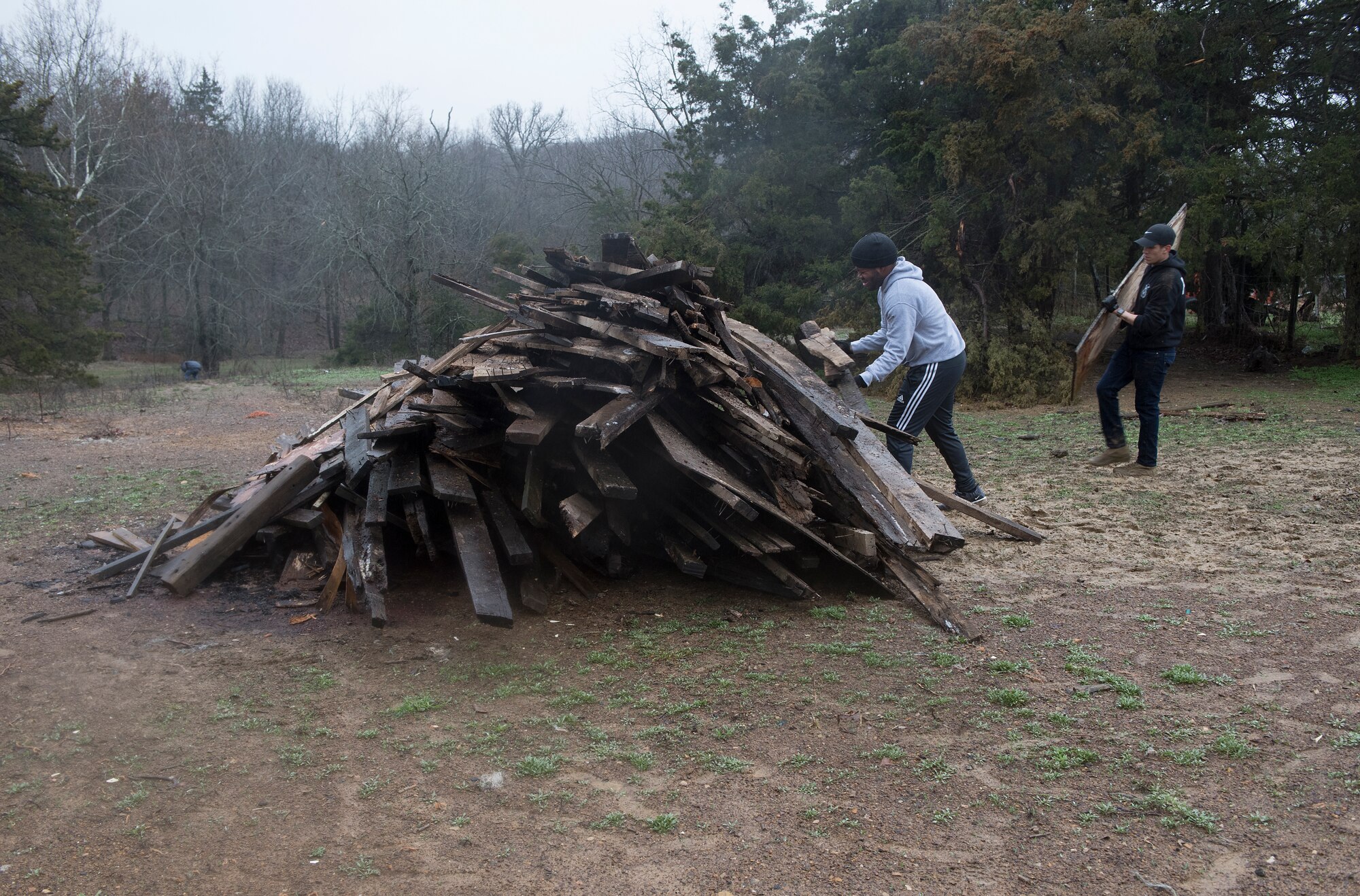 Airmen 1st Class Noah Singleton and Miguel Tapia, security forces response members assigned to the 509th Security Forces Squadron volunteered their time on a Knob Noster, Missouri farm to assist a local Vietnam War veteran and former security policeman to clear parts of his property.