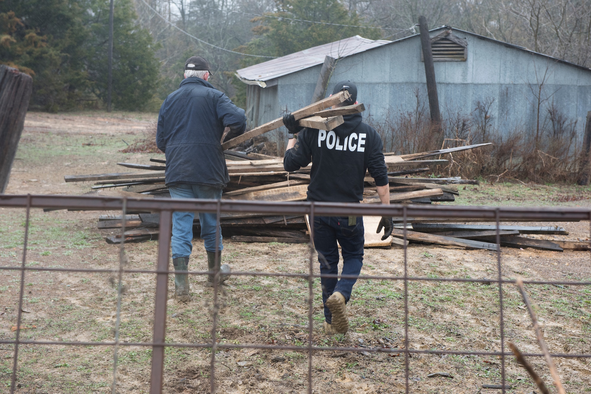 Airman 1st Class Miguel Tapia and Vietnam War veteran Todd Conner move scrap wood to a pile on March 20, 2019, at Conner's farm in Knob Noster, Missouri.