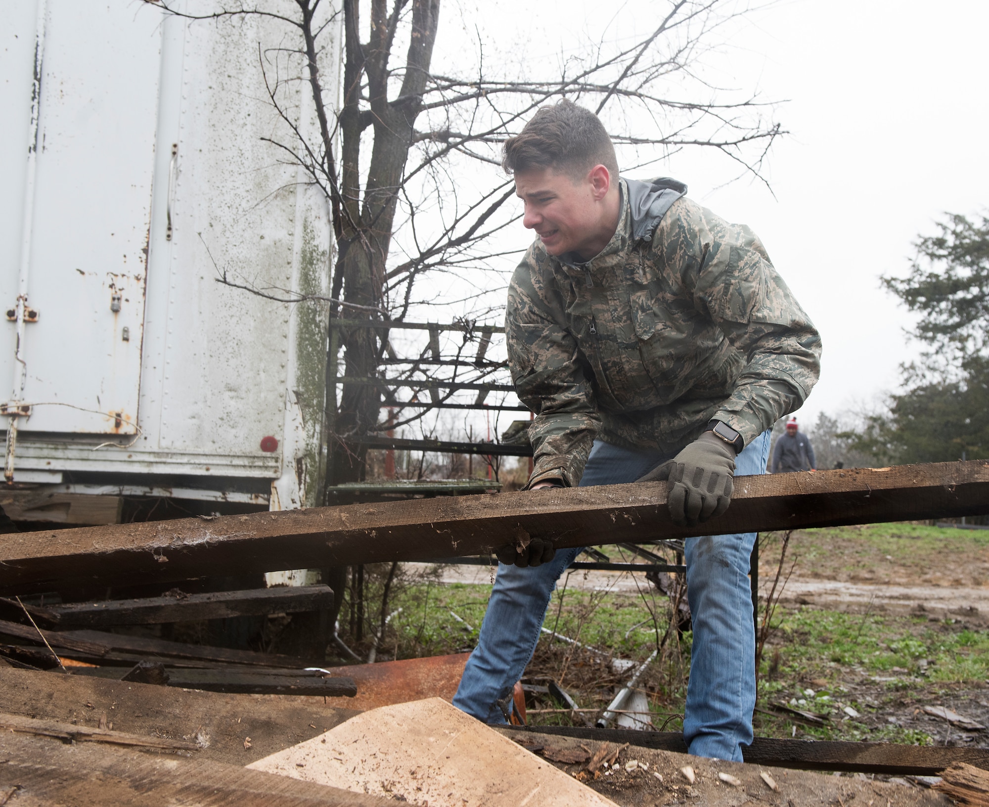 Airman 1st Class Charles Kost lifts a piece of discarded wood on a farm on March 30, 2019, in Knob Noster, Missouri.