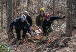 First responders carry a litter containing a dummy during a simulated wide area rescue operation held March 30-31, 2019, at the Hobet All Hazards Training Facility in Julian, W.Va. This training marked the first course to be offered at the Hobet All Hazards Training Facility. (West Virginia National Guard photo by Bo Wriston)